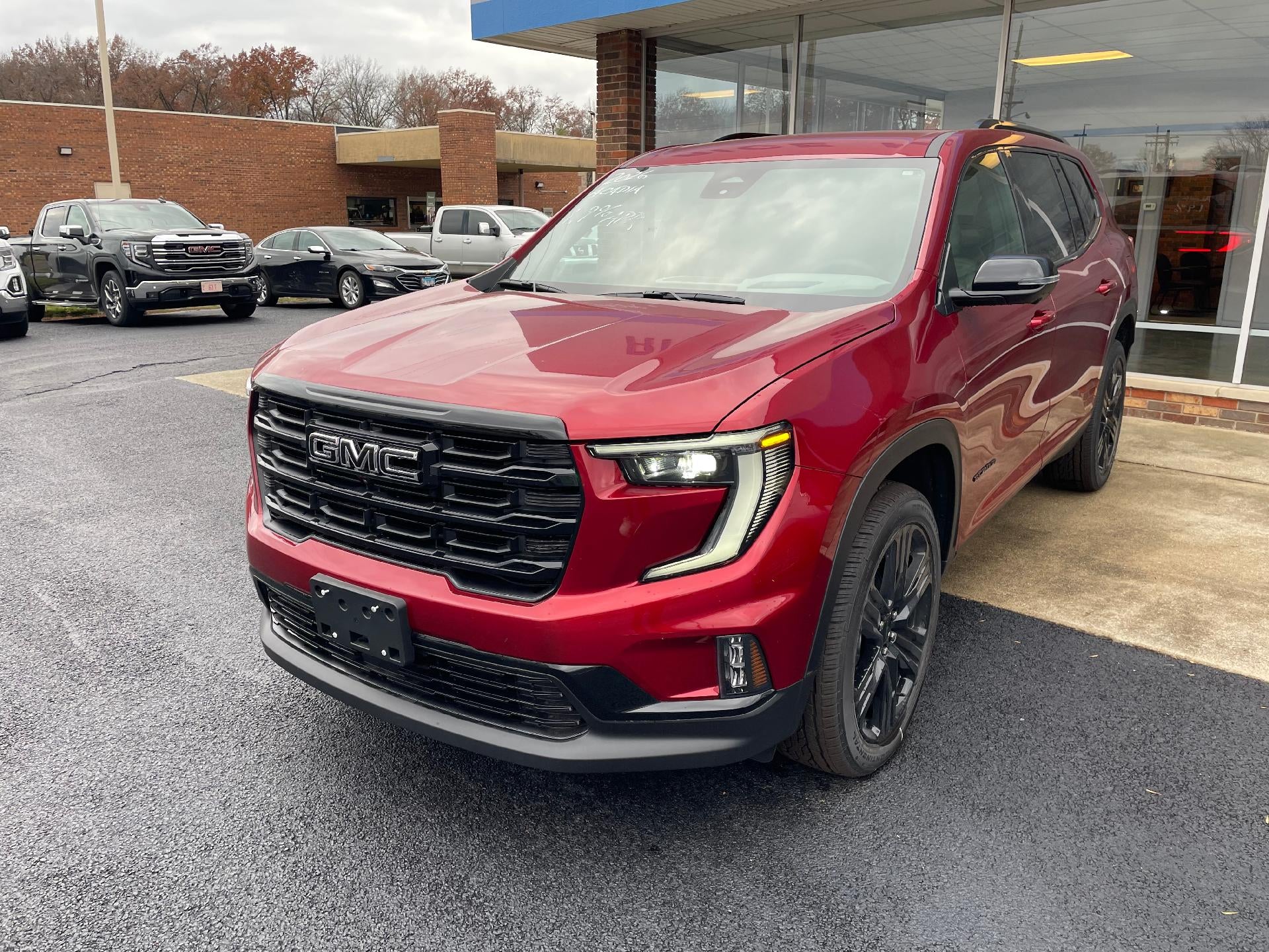 2026 GMC Acadia Elevation in Volcanic Red Tintcoat — front three-quarter view